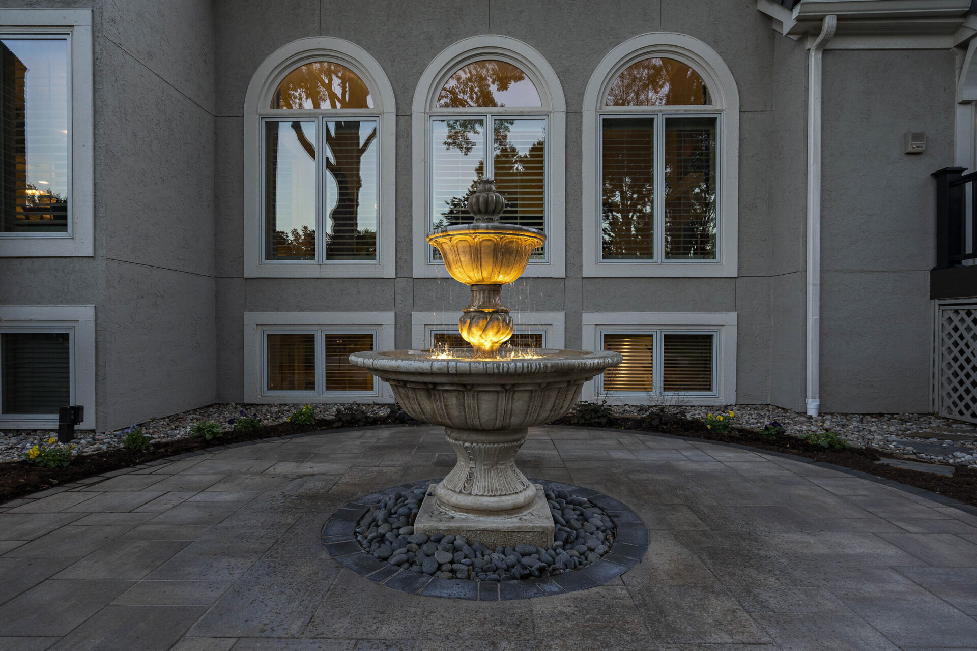 A well lit fountain in a home yard