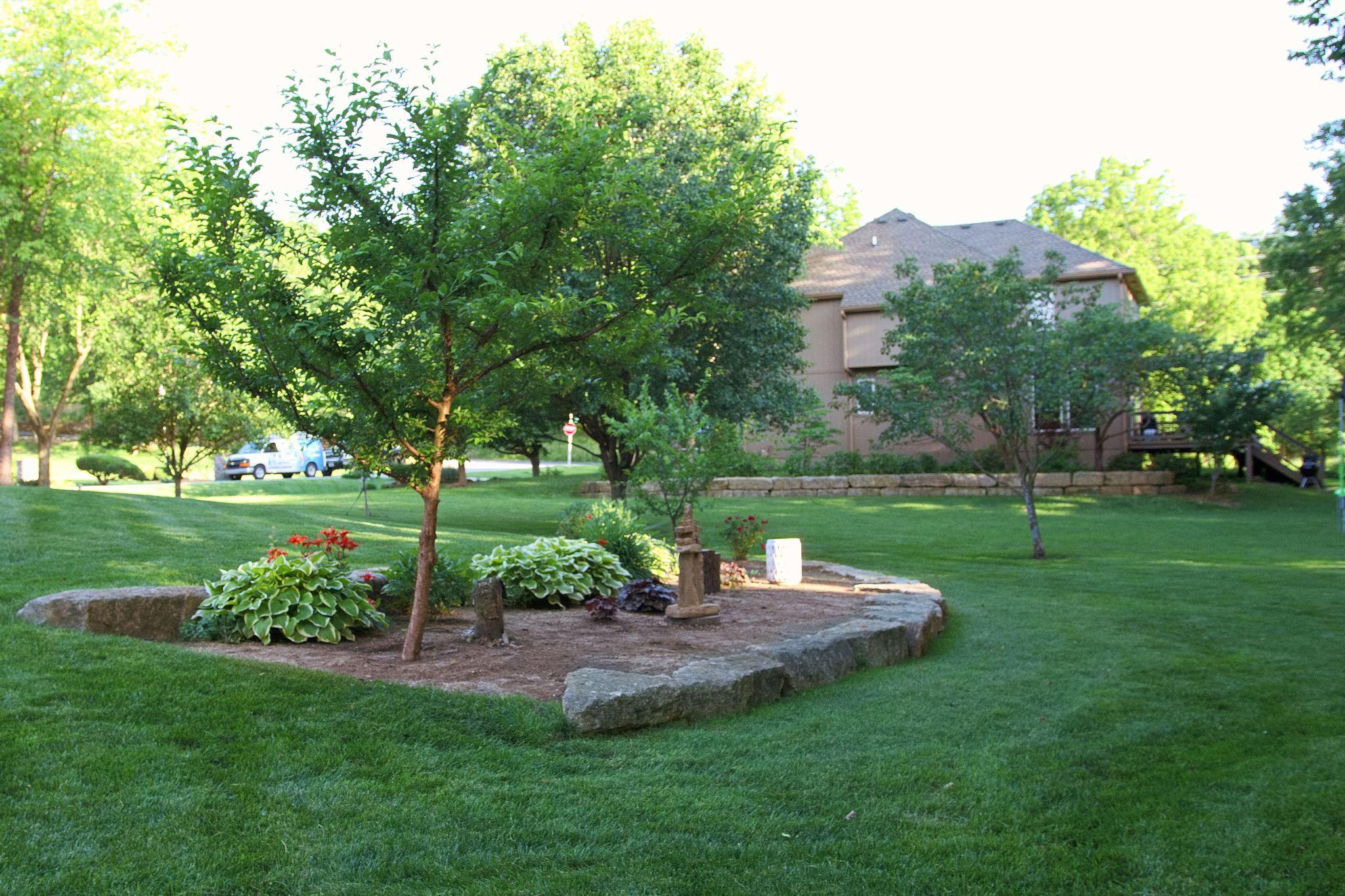 Backyard lawn with stone-edged planting bed